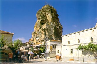 Мощная глыба изрезанной пещерами скалы в центре Ортахисара
